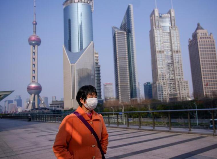 资料图片：2020年2月，上海，一名女子经过陆家嘴金融区。REUTERS/Aly Song