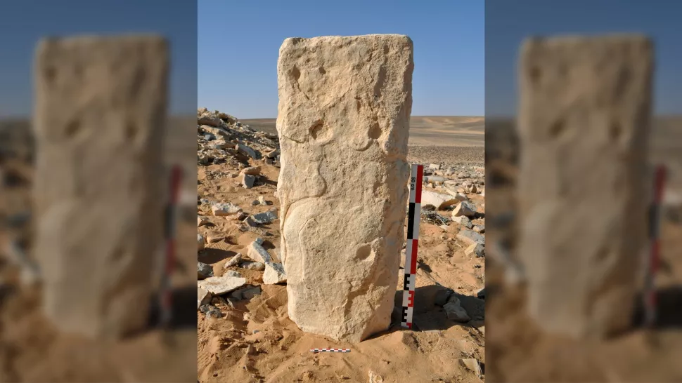 在约旦的 Jibal al-Khashabiyeh 遗址发现时的雕刻石头照片。 （这块巨石被发现是躺着的，为了拍照而垂直放置。）（图片来源：SEBAP & Crassard et al. 2023 PLOS One）